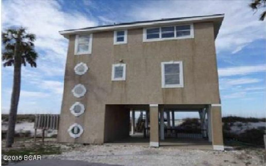 Island home with beautiful Gulf of Mexico view! This 3 bedroom/3 bath home can be a wonderful vacation home or a terrific home in paradise. There is a 4 space carport on first level and space in the drive way for guests. The rear of the home feature two floors of covered deck porches with access from bedrooms and great room on 3rd and 2nd floors, these decks face the gulf with panaramic Gulf views. You can walk over the dunes with direct access to white sandy  beach. The great room has windows and french doors withviews and access to the deck. The kitchen is large and has an extended breakfast bar. A must see!