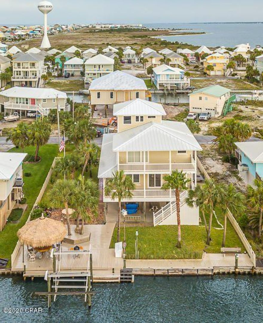 The 3rd level viewing room offers 360 degree Gulf/Intracoastal views that could be anything from a sitting room to office or gym.  Bring all of your toys - 10K lb boat lift, 80 ft reinforced seawall with post set up for jet ski lift. Outdoor shower to clean up after playing all day. Parking pad on side of house for trailer or RV - no HOA. There's room for a pool as well. The three car garage with 1/2 bath and workshop area provide ample storage and covered porch off the back. An entertainer's dream - tiki hut with composite wind and fire rated roof, waterfall fountain and fire pit with new wood decking surrounding the area. The owner's have thought of everything with numerous outdoor electric outlets, water sources, 100 gallon propane tank with multiple hookups for gas grills and a high pressure outlet for shrimp/crawfish boils. There's even a setup to unload a portable gasoline transfer tank to avoid filling the boat up at a marina.

Upgrades include 2 new Geothermal HVAC units, water heater(2018), irrigation well and central vac. Impact glass on all openings except for 2 sliding glass doors(coverings providing) and metal roof. Dumbwaiter runs from garage up to master bedroom with plans drawn up to convert to elevator. Estimated $80k annual rental income.