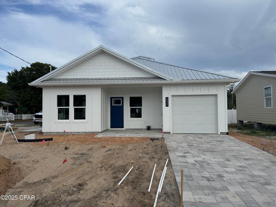 Welcome to this stunning brand new construction beach home located in the heart of Laguna Beach on the West End of Panama City Beach, just two blocks from the pristine white sands and emerald waters of the Gulf of America and walking distance to Thomas Donuts. Positioned on a desirable corner lot, with a Gulf view from the front this thoughtfully designed home features two spacious bedrooms, two full bathrooms, a versatile bunk room, and an attached garage—perfectly blending comfort, function, and coastal charm. From the moment you arrive, the crisp white board-and-batten exterior, shake accents, and striking blue front door with paver driveway creates eye-catching curb appeal. A durable metal roof and impact-resistant windows provide both style peace of mind. The brick paver driveway and walkway enhance the entrance, setting the tone for the craftsmanship found inside. Step into a bright, open interior adorned with crown molding, shiplap accents, and detailed window trim. The kitchen is a showstopper, offering all-wood custom cabinetry with soft-close drawers, quartz countertops, a tile backsplash, under-cabinet lighting, and a full suite of high-end GE appliances.

The open living space is highlighted by a tray ceiling and soffit lighting creating elegance and architectural interest. Throughout the home, luxury vinyl plank flooring offers beauty and durability, while tile flooring in the bathrooms and laundry area adds a practical and polished finish. Both bathrooms feature matte black plumbing fixtures and modern styling. Step outside to enjoy a private brick-paver side patio, an outdoor shower for rinsing off after beach days.

Whether you're looking for a permanent coastal residence, a second home, or a high-return investment property, this beach cottage offers the perfect blend of quality construction, timeless design, and an unbeatable location just steps from the Gulf.