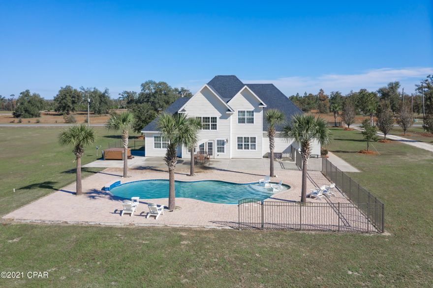 Beauty awaits you as you step inside this executive 3-bedroom, 3 bath luxury home! This rare find boasts over 5,000 SF and is situated on a spacious, well-manicured 5 acres! Upon entering you are greeted with a grand foyer, stunning bamboo floors, expansive molding, a formal dining room that leads into a kitchen fit for a chef boasting custom cabinetry, cambria countertops, breakfast bar, pot filler and stainless-steel appliances. Also located on the main level is a spacious living room filled with an abundance of natural light and over 18ft cathedral ceilings, family room, full bath, laundry room and a luxurious master suite featuring trayed ceiling, jetted tub, double vanities, custom tiled shower and his/her walk-in closets. Upstairs you will find a loft overlooking the living room, 2 bedrooms, full bath, media room, and an office space. The backyard is your personal oasis equipped with a custom gunite pool with deck jets and tanning deck, large paver patio, 24x40 enclosed heated and cooled shop and an additional 48x80 open pole barn. Home is located on a paved road just a short drive to I-10 and Marianna.