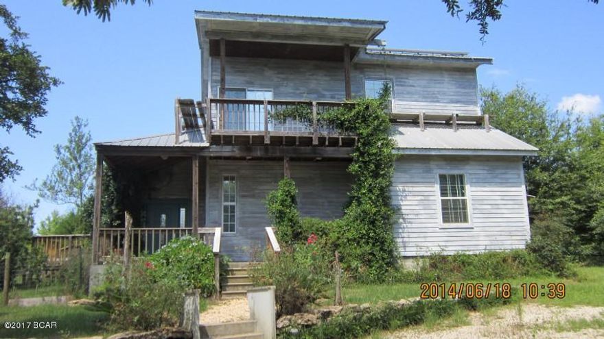 Horse Property: Two parcels, total 9.0 acres, with perimeter fence (much is privacy fence), cross fenced, round pen, 4 stalls, large shed and 3 small sheds.  All wire fencing is smooth white poly wire, 4 strand, land mostly cleared with Argentina Bahiagrass pasture. Small Cypress pond has been excavated on one end to make fish pond. Unique 2 story, open floor plan house, 2 b/r, 2 bath, (top floor being one of the bedrooms and a bath). Living, kitchen, dining rooms combined, front and rear porches and a balcony. All appliances stay. Two wells, 2 septic tanks, in ground concrete pool with fence, fruit and citrus trees, two garden areas. Kitchen has metal ceiling and metal back splashes. Some owner financing considered, make proposal.