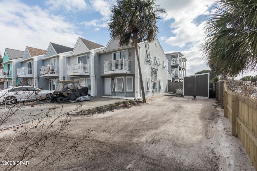 NO HOA FEES!! 2 bed 2.5 bath end unit with 41' rd frontage giving you a nice side yard with a 8X12 storage building. Oversized parking to accommodate at least 4 vehicles. Immaculate condition, sit and relax on the screened back porch and listen to the waves roll in. Located just 4 blocks to Schooners and a short walk or Golf Cart ride to beach access 7. Also close to St Andrew St Park as well as shopping and restaurants. Backyard oasis is perfect for grilling and entertaining family and friends. Privacy fenced back yard with gate access to the side and front yard. Location is perfect for vacation RENTAL OR PRIMARY HOME. Offered furnished except for personal items and an itemized list to be provided. Recent update; Roof-2014, HVAC-2015, Hot water 2019 as well as stainless appliances and washer/dryer. Sept 2021 property connected to sewer, Aug 2022 screened porch added also granite counter tops, LVP laminate flooring installed on stairs and all of 2nd floor. Sept 2022 Hurricane shutters and all window blinds installed. 2nd floor offers 2 bedrooms each with private baths. The front bedroom has small walk in closet and bath has tub/shower combo as well as a balcony, additional bedroom has his and hers closet and private bathe with walk in shower. Could be a great money maker or personal piece of paradise. Call for private showing today.