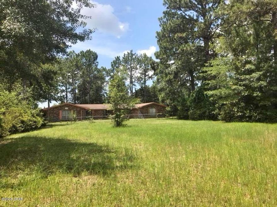 Currently under contract, seller accepting backup offers. Almost 5 acres to develop or have for your horses/homestead/mini farm. Within 15 min. of Panama City.  Fenced and crossfenced w/28x52' barn and additional storage building w/covered work area. Purchase now and update yourself to build your equity. Brick ranch 4br2ba and 2 1/2 baths. Living rm, dining rm, family rm with fireplace looks out to screen porch. Also has vinyl lined pool inside fully enclosed screen room with roof where you can enter the house through laundry room that has 1/2 bath. Prevents swimmers from tracking water through house. Kitchen has lots of storage with Jenn-air cooktop in the island. Update and make it your own style.