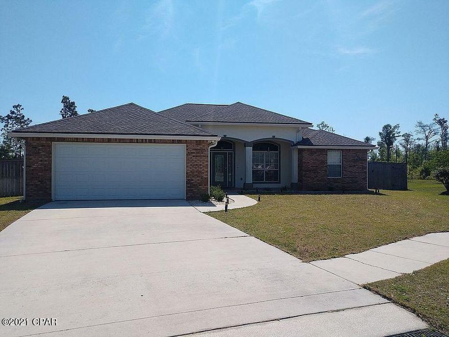 Fully bricked move-in ready 3/2 home in beautiful Cedars Crossing. This home is located in a cul-de-sac, with a stunning pond and woodland view. The front porch features wood like tile and hanging, street lamp style light fixtures. Inside you'll notice the large open-concept social areas with hardwood and large porcelain tile flooring; along with beautiful crown molding that finishes the 10' ceilings. The kitchen has been remodeled with black stainless-steel appliances, gorgeous backsplash, huge 10'' stainless-steel sink, and dark oak butcherblock countertops. If you're looking for a great location – look no further – you'll be just minutes from shopping areas, Tyndall AFB, downtown PC and the most beautiful beaches on the gulf coast!