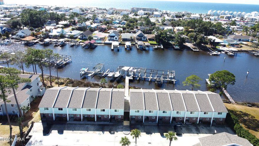 CURRENTLY UNDER CONTRACT, SELLER WILL CONSIDER BACKUP OFFERS. Bring your boat! This waterfront home has a deeded boat slip and electric lift. The Lagoon leads boaters to the beautiful waters of the Gulf of Mexico.. Enjoy sitting on your open air patio watching the dolphin jump and boaters on their way to enjoy all that Panama City Beach has to offer. Imagine fishing on the dock for your own catch or take a boat to many of the water side restaurants in the area. Living is easy with kitchen, living room, half bath and laundry on the first level. The two bedrooms are on the second level and each bedroom has a private bathroom. The master bedroom overlooks the lagoon with a bonus area for enjoying all the views provided by nature. Roof metal and new in 2021, Complete AC system new in 2020,  Master bathroom remodeled in 2020, Front windows upgraded in 2020, Master bedroom  storm windows upgraded in 2021, Appliances in kitchen new in 2019, Boat lift and slip updated in 2022. Plus many more recent upgrades. Landward has a community pool. This home is ready to enjoy for many years to come. This beautiful waterfront home with boat slip, lift and dock will not last long. Come see it today.