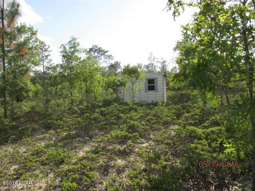 Want a peaceful/private place to put your home or just a getaway?  This 5 acre parcel is only 35 minutes from Panama City, close to shopping, hospitals and beaches!  Grocery store is close.  Property has been previously cleared and is fenced in.  Nice storage building with electric on site.  All it needs is you!