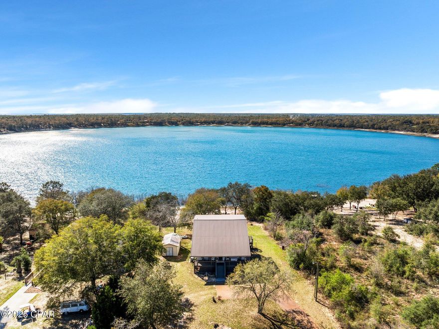 1% PREFERRED LENDER CREDIT - ANY BUYER, ANY LOAN, ANY AMOUNT!!! In addtion to this credit, that view is all you need to know! Whether you prefer sunrise or sunset, this lake house is the place for you. A peaceful slice of property that allows you to enjoy time with the birds chirping, the water glistening, and quiet country living on 1 acre. The main house has two bedrooms and two full baths. The studio apartment downstairs serves as a third bedroom with a private entrance, kitchenette, jetted tub, and walk in closet. Its perfect for a rental or multigeneration family dynamic. The home has a grand entrance up to the charming front porch and welcomes you to an open layout with a fireplace that stands as its own feature. The loft overlooks the living area on one side and overlooks the lake on the other. It's a versatile space you can use to your preference - office, library, gym area, sleep over space for the Grands - so many options. The dining and kitchen are situated well for socializing, and they give plenty of space for cooking and hosting. 2 balconies give you a perfect view of the lake and the lower patio could be a fun space for an outdoor bar and kitchen, fish cleaning area, firepit, lounge space or all the above! This home has plenty of benefits you can see, but can you find the secret Harry Potter room?  You'll have to come look in person! The very minimal HOA gives you the benefit of a community pool, basketball court, tennis court, and boat launch. The seller is leaving the pedal boat, riding mower, and most importantly, the Starlink Satellite, giving you the best high-speed internet capability making working from home a breeze. All measurements approximate, buyer to verify if important.