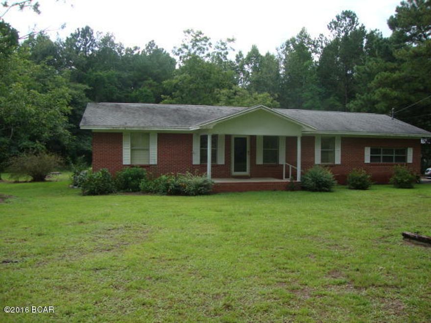 3 Bedroom 2 Bath Brick home on 4+ Acres at the edge of town. Large country kitchen with lots of cabinets, nice counter tops and eat at bar. Open concept. Split bedrooms. Nice Florida Room. Two Bonus Rooms.  Attached carport. Concrete driveway and parking area. Frontage on paved street.