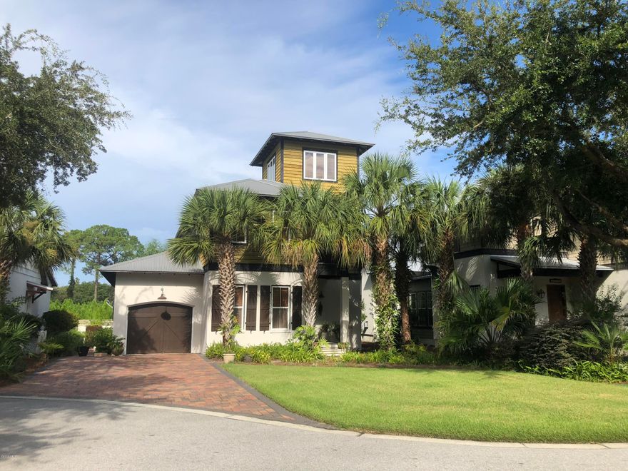 Beautiful 3 story West Indies style custom home. 3 bedrooms 3 full baths plus bonus room tower with views of Grand Lagoon offers many upgrades and details.  Concrete block construction on first floor, cedar siding on 2nd and 3rd floor, metal roof, 10 Ft. ceilings, all wood floors, travertine in bathrooms and laundry room and porches, custom wood cabinets, built in entertainment center including surround sound with volume control for each room, stainless steel Kitchenaid appliances with warranties, chimney hood, new double oven, granite counter tops, farm sink, all wood interior doors, custom lighting package, wainscoating and more. Martinique is a gated community with amenities including pool, playground, & walking trails.  Call to see this beautiful home today!