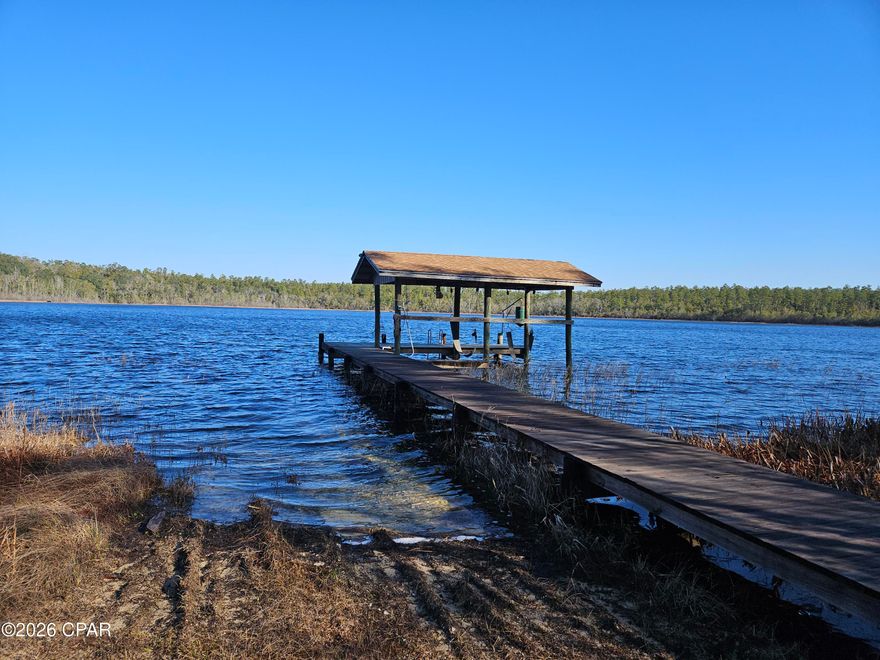 This 475 (+/-) acres offers owner financing zoned Agriculture along with the front 100 acres that has highway frontage is zoned Commercial. Right now it is a hunter's paradise with 4 lakes, the larges being 30 acres with 3 docks, one of which is covered and has a covered boat lift. This is the clear lake that the house overlooks. It has 2 bedrooms, 2 full bathrooms, an open floor plan and a large screened-in porch for cooking, cleaning fish or enjoying the lake view. It also has a 2-car garage for tractors, four-wheelers and other equipment. All of the property is fenced in and has access from the highway with a median cut, and along Greenhead Road. The total acreage is from combining 8 parcels that are contiguous. Taxes shown are from the parcel that has the house on it. Click on the Documents tab to see the survey of all 8 parcels along with potential uses of the commercial 100 acres. The price for the 475 (+/-) acres per acre is $14,526.32 that includes all 8 parcels combined. The property is less than 25 minutes to Panama City International Airport, and 35 minutes to Panama City Beach. This property is close to Sunny Hills Golf Course.