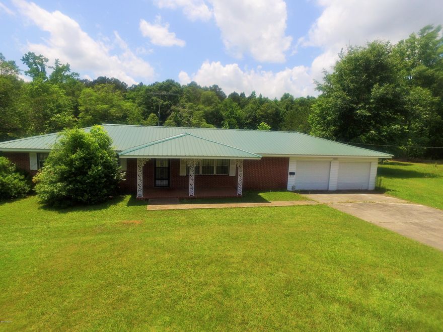 Very nice 3/2 brick home located in Graceville.  Home needs a little TLC but is in overall great shape, home has a newer metal roof.  Home sits on approx 3.5 acres(will have to be surveyed to get exact size)and has a beautiful pond with a island in the middle of it.  There are two adjoining homes that are being sold for $25,000.00 each.  You could purchase all three and rent two. Subject is PROPERTY ''1'' in aerial view located in the photos.