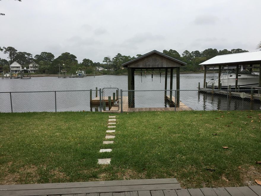 A boater's paradise, this home is a 10-minute boat ride to the Gulf and offers comfortable style. Attention to detail describes this home located a few minutes to the beautiful white sand beaches. Tiled floors, large windows to capture the lagoon view. The new Grand Lagoon bridge adds another 12 feet for your boat height. Park your boat, great layout, and covered deck overlooking the Grand Lagoon.  Enjoy relaxing on the deck overlooking Grand Lagoon, or live it up on the water, fishing, kayaking, paddle boarding, jet skiing, and boating. Beautifully remodeled home on Grand Lagoon in Panama City Beach. Brand new Stainless Steel appliances. The refrigerator has dual ice maker's. Granite and Quatrz countertops, new bathroom vanities, new HVAC system with complete duct work cleaning, new Roof, new lighting, flooring, tile flooring, Completely fenced in front and rear yard, new dock, new faucets and fixtures throughout the house. This house also boasts a 2 car garage with a work area.