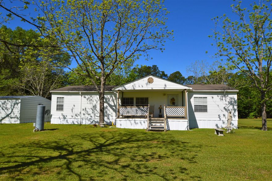 Location!!! Location!!! Location!!! Well maintained doublewide sitting on over 4 acres, juts minutes from town. Property sits on corner of Falling Waters and Tharpe Rd. Inviting front porch leads to open floor plan, split bedrooms and updated flooring. Spend afternoons on oversized screened back porch. Detached 2 car carport with storage (window ac) Property also includes Block building that was used as office space, but easily could be converted to apartment or mother in law quarters. Lots of Potential!