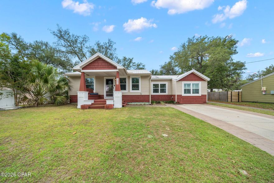 Across from the Bay in the historic Cove neighborhood sits a home exuding charm and character offering 3 bedrooms, 2.5 baths, a detached home office with an adorable front porch! This Cove cottage features almost 1800 square feet of living space with a large open deck on the back, overlooking the shaded back yard, perfect for entertaining. You're greeted with a cozy, covered front porch and enter into a stunning great room with custom millwork throughout including a stunning coffered ceiling flowing throughout the living room, kitchen and dining area. The living room is flooded with natural light, spacious and includes a separate area great for kids to play or would function as a great conversation area. The kitchen is outfitted with beautiful granite countertops, stainless steel appliances and a gas cooktop with accent lighting above the cabinetry. The dining room overlooks the backyard with lush oak trees. Just off the kitchen is a guest bedroom with en suite bath complete with a tub/shower combo. An additional guest bedroom is found toward the back of the home off the dining room. A great feature of this home that is rare in Cove homes is a half bath which is in an excellent location for guests - just off the living room area. The hallway with the powder room leads to the primary suite which is a true retreat! The primary suite includes double closets, vaulted ceilings, natural light and a en suite bath to include a dual shower head, oversized tiled shower, double vanities and water closet. This home is a true split floor plan! One of the best features of this home is the building in the backyard. This 2023-built permitted outbuilding has a home office complete with plumbing and electrical and a half bath. This is an incredibly desirable feature for those who wish to work at home but be separated from the home for work. The outbuilding also has a work shop area great for hobbies and outdoor work. This building is also insulated for temperature control and encapsulated to keep it free from pests. The right side of the home also gives access to a city-maintained alley that runs along the back yard fence and gives easy access for trailers, boats, etc. 1604 Tyndall Drive offers a 2020 roof, 2019 windows, 2020 HVAC, tankless water heater, whole house surge protector, Aquasauna water filtration system (complete with 6 months of filters!) and 2017 Maytag appliances. The Cove is a charming golf cart-friendly community with NO HOA and highly sought after for it's water views as well as its city-maintained playgrounds and parks. Just 2 homes down from this home you'll also enjoy a baseball field and new playground area for kids and families. Enjoy events in the community throughout the year! This neighborhood is adjacent to the fast-growing downtown Panama City area which features restaurants, a marina, shopping, breweries, farmers markets and events year-round. The St. Andrews Bay Yacht Club is an incredible offering as an addition amenity in the neighborhood and just a few minutes away. Ideal for boaters, fisherman and those who love to enjoy events, as a member, you will enjoy access to a private boat launch, dining waterfront and activities weekly. 1604 Tyndall Drive in the heart of the Cove is waiting for you!