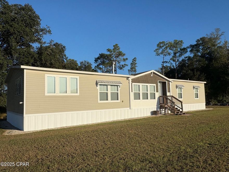 Check out this stunning 2020 mobile home featuring 4 bedrooms, 3 bathrooms, and 2,280 heated/cooled sq. ft. of living space — all set on a peaceful, secluded 1-acre lot overlooking large acreage. Enjoy breathtaking sunsets or simply relax while watching the local wildlife.

Inside, you'll love the wide open floor plan with 9-foot ceilings throughout, a cozy wood-burning fireplace, and a wrap-around kitchen with a large center island accented by pendant lighting. The kitchen also features stainless steel appliances and plenty of counter and cabinet space.

The split-bedroom design provides privacy, and the spacious primary suite is truly a retreat — complete with a luxurious bathroom offering a double vanity, soaking tub, step-in shower with rain shower head, and a large walk-in closet.

Laundry won't feel like a chore here! The laundry room is oversized and includes built-in cabinets, a sink, and a convenient hanging rack for clothes.

Enjoy the perfect blend of privacy, space, and modern comfort — this home has it all!