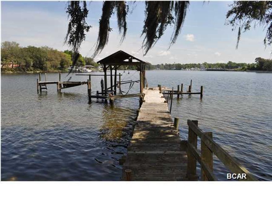 SELLERS SAY TIME TO SELL! Great waterfront estate in the Cove on Watson Bayou. Approx 100' on deep water, you're just around the bend from the bay and 10 minutes from the pass. This property has one of the highest elevations on the water in Bay County and it's not in a flood zone. Solid brick construction for this classic home with a split-bedroom floor plan, some original hardwood floors, built-ins, tons of interior storage and a workshop. The home needs some updating, but you could easily restore it to its original charm. If you're raising a family, the location couldn't be better as the Cove Ln Park is just across the street. And boaters, there are several public boat ramps nearby! All info is approx. and must be verified by Buyers if important.