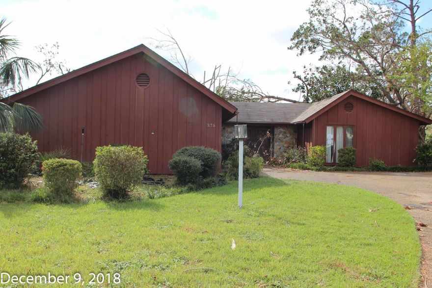 This large, canal front property has suffered some damage from Hurricane Michael but has great potential.  The living room is large with a vaulted ceiling and a fireplace.  The large kitchen has an island cook top range with a wall oven.  There are a lot of cabinets and counter space.  There is a covered porch area over looking the canal with a large deck for outdoor entertaining.  The bedrooms are all on the opposite side of the home with two full bathrooms.  The home will need a roof, some updating but if you are looking for a fixer upper this one would be a great investment.  This property may qualify for Seller Financing (Vendee)  Home is on the canal and will be accessed a Canal HOA of $250 a year.