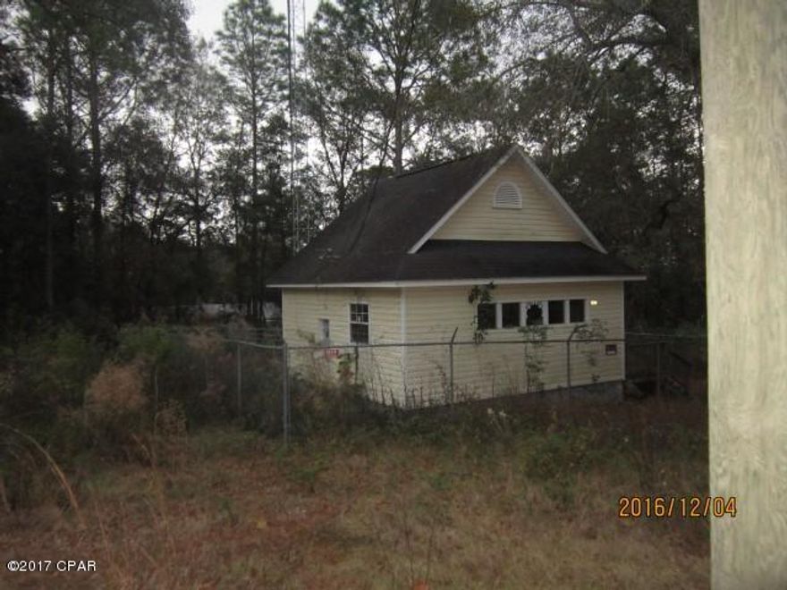 Currently zoned Commercial.  Consists of 3 city lots totaling just over 1/2 acre, located in residential area but zoned commercial to accomodate this building which was built for a Remote TV Studio for Faith-based owner. Best use would be for residential with water and sewer added. City advises cost to hook up water and sewer is $7000, plus cost to run lines and set up bathroom and kitchen inside the house.  Building consists of 2 rooms with closets and unfinished bathroom, meaning no bathroom fixtures, just a room.  There is one wall unit AC in back bedroom. There is no kitchen and that would need to be added in front room.   Lot is fenced.