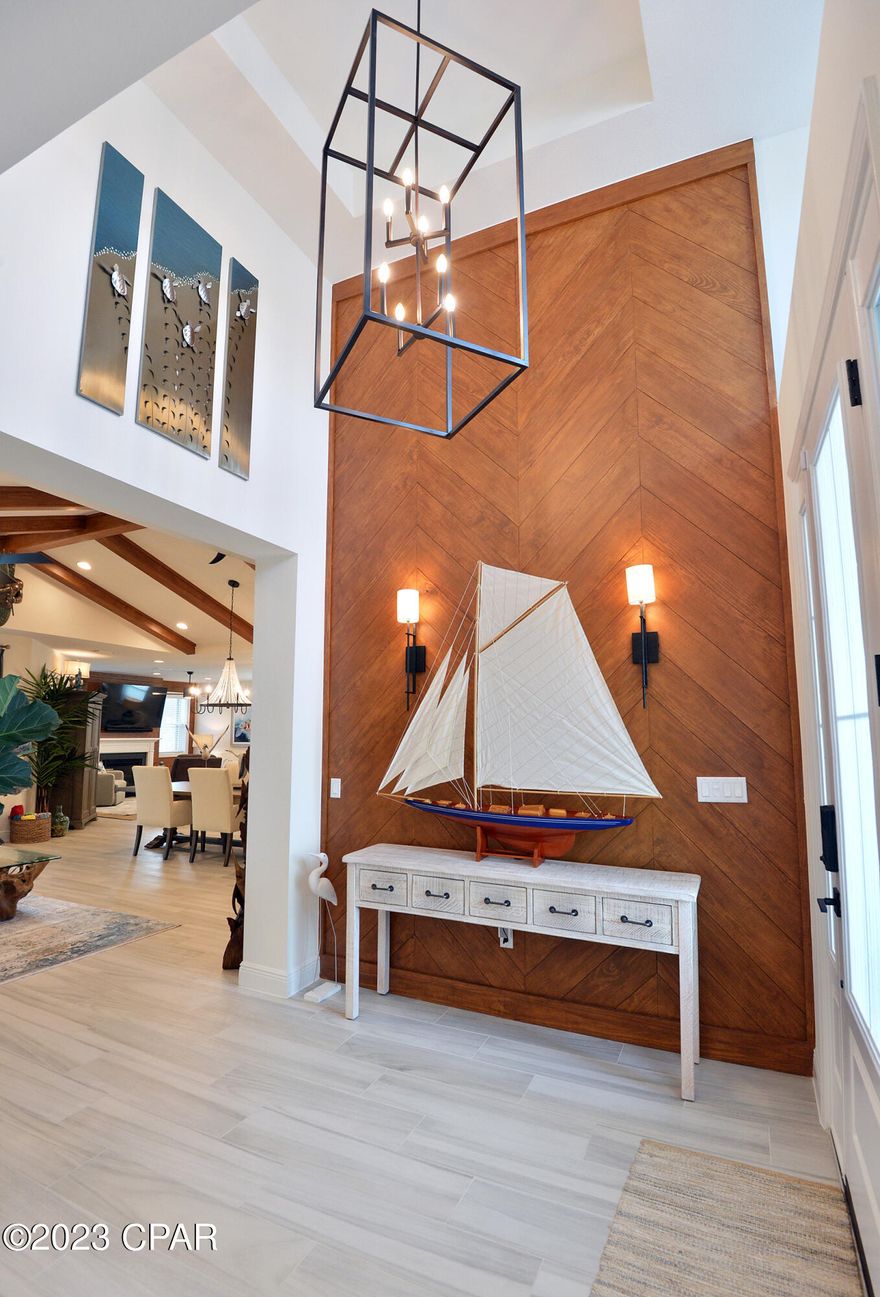 CURRENTLY UNDER CONTRACT, SELLER WILL CONSIDER BACKUP OFFERS. Don't wait 2-2+ years on the list to build-get in now! Come see this beautiful, barely lived in Trinidad Bay home in highly sought after Latitude Margaritaville Watersound, an exclusive 55+ community located along the Emerald Coast and intracoastal waterway in Panama City Beach! This 3BD, 3½ BA, 2,549SF home on a preserve lot features tile flooring throughout. Upon entering you'll notice the cathedral ceiling foyer adorned by a beautiful fruitwood stained, herringbone wall with wall sconces. You'll enjoy the open living room, DR/kitchen featuring beautiful fruitwood stained beams which makes the perfect area for entertaining. The kitchen is nicely appointed with all high end Kitchenaid appliances, quartz countertops, vent hood in addition to a large island and walk-in pantry. You'll notice the focal point gas fireplace in the family room you can enjoy in the cooler winter months. The primary suite is a generous size with his/hers walk-in closets w/an ensuite bath featuring dual vanities and a glass enclosed, walk-in tiled shower. The den may be used as an office or whatever your heart desires along with two additional guest bedrooms, both with en-suite baths. The laundry room is amazing with a sink and endless cabinets to easily store and hold those items you don't use that often. You will want to spend loads of time out on your covered lanai grilling on your outdoor grill & bar (which remains w/the house) watching sports or listening to music from the Sonos sound bar while enjoying the pool and spa. There is no lack of space in the 3-car garage. This golf cart-friendly community offers endless daily activities and the Latitude Town Square features live music & entertainment at the bandshell, resort-style paradise pool w/live music daily, pickleball, tennis & basketball courts, Barkaritaville Dog Park, Fins Up! fitness center w/indoor lap pool, putting green, bocce ball, pool & ping pong tables, a kayak launch and the 2-story Bar & Chill restaurant overlooking the intracoastal waterway w/phenomenal sunsets. Commercial businesses set to come in the near future include a grocery store, bank and so much more. Get your new attitude in Latitude-it's all about the lifestyle!