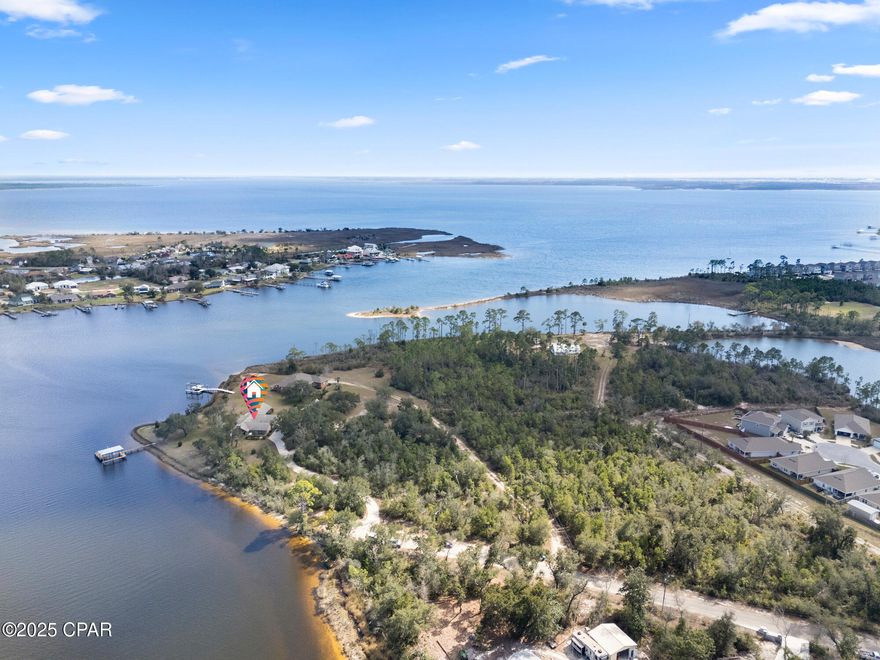 7300 Boat Race Road. This stunning 10+ acre waterfront property in Bay County, includes over 900 feet of frontage on Callaway Bayou. With easy and direct access to East Bay, St. Andrews Bay, and the Gulf of America, this prized location sits on a point, offering unmatched panoramic views of the water and surrounding wildlife habitat. The home combines luxury and functionality. The gourmet kitchen features a custom breakfast bar, two dishwashers, a built-in ice maker, separate below counter freezer drawers, a Sub-Zero refrigerator, a five-burner propane gas cooktop, a vented range hood, a warming drawer, and a convection microwave oven. Vaulted ceilings with exposed wood beams enhance the open floor plan of the main living areas. Crown moulding throughout the home highlights the attention to details. With its own unobstructed view of the Bayou, the master suite includes a large walk-in closet, a separate cedar-lined closet, and also a private office. The spacious en-suite bath includes a walk-in shower, a separate jetted garden tub, double vanities, and a bidet. The guest wing of the house includes a large bedroom, full bathroom with a walk-in shower, a dining/living area with a wet bar. Separated from the main house by a pocket door, the guest wing has three external entry ways: a main door with foyer, access to a private patio from the bedroom, and access to the Bayou from the living room. Additional highlights include a whole house standby propane generator package, a central vacuum system, two geothermal HVAC systems, and two electric water heaters, and low-profile retractable hurricane shutters.  The exterior of the property is equally impressive, featuring a boat dock with a covered slip and boat lift. There is an attached garage as well as a 2-car detached garage with an exercise room, and a spacious loft area, ideal for storage or future expansion. This waterfront-front property is a unique and extraordinary Estate.