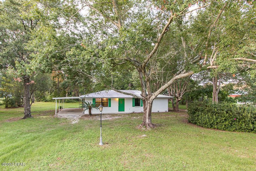 Don't miss the opportunity to own this affordable move-in ready home! Enjoy the peacefulness of this neighborhood while being conveniently located to shopping, schools and Tyndall Air Force Base. This home is nestled away on over an acre lot with beautiful mature trees including multiple pecan trees throughout the property. This all block home features a newer metal roof and AC that are approximately 6 years old, an oversized carport, and a large screened in back porch. When you enter the home you will notice the new carpet, fresh paint and a very large walk-in closet in the master bedroom. Mobile home on property does convey but no value was given to it. This mobile home could make a great income producing property with a little TLC. Don't waste any time, schedule your showing today!