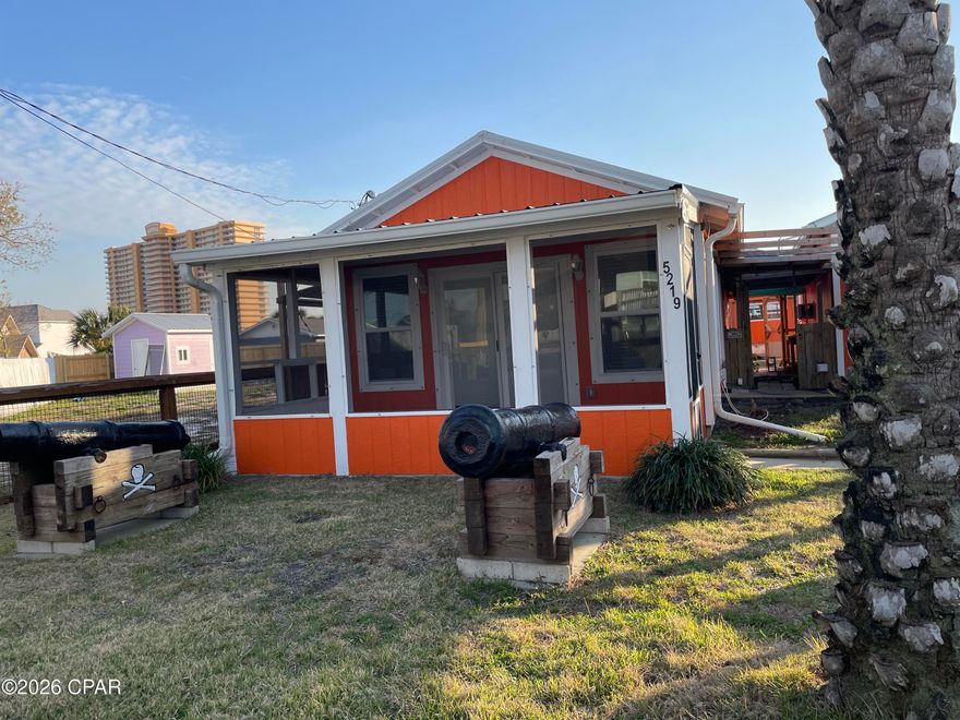 Welcome to Pirate's Paradise, a truly unique coastal cottage complete with two authentic, themed cannons that set the tone for this fun and memorable beach escape. The detached one-car garage and oversized storage shed adds extra value to this one-of-a-kind property. Perfectly positioned in one of the best locations on East Panama City Beach, you're just an 8-minute walk to Beach Access 4 and Schooners, and only a 3-minute drive to St. Andrews State Park, ideal for beach days, boating, and exploring the Gulf Coast's most beloved natural areas.

Built in 2016, this charming home features durable Hardie board siding, a metal roof, a welcoming screened front porch, and a fully fenced yard for privacy and outdoor enjoyment. Major mechanical peace of mind comes with a new AC installed in 2024. 

Inside, the home offers a bright, efficient layout with thoughtful upgrades throughout including:
Ceramic non-slip tile flooring - durable, and perfect for sandy feet, open-concept living and kitchen with granite countertops and island bar, inside laundry hookup, spacious primary suite with walk-in closet, new 2'' blinds throughout, and a huge walk-in tile shower with a new vanity in the bathroom. Move-in ready or rental-ready with low-maintenance finishes.

The detached one-car garage is a rare opportunity for additional rental income potential with insulation, walls, and laundry hookup already installed. Finish out as a studio with kitchenette, or a guest suite. It's currently split into a bedroom on the backside and a golf cart garage with a laundry hookup in the front. It can easily be converted back to an oversized one-car garage or finished out as a studio apartment.

A large backyard storage shed adds even more flexibility - ideal for a game room, workshop, hobby space, or extra storage.

Whether you're seeking a personal beach getaway, a short- or long-term rental, or a property with room to grow, Pirate's Paradise delivers unmatched character and potential in one of Panama City Beach's most desirable areas.