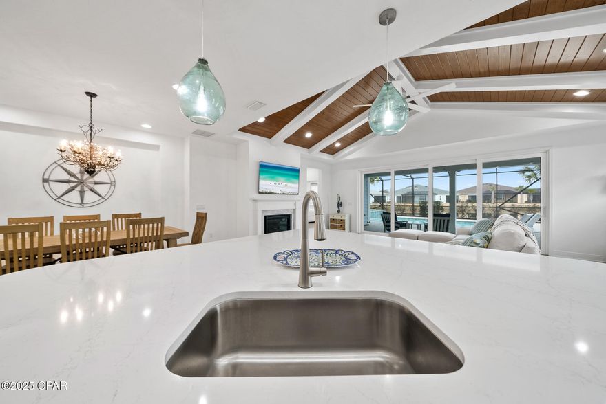 Exquisite Waterfront Living in Latitude Margaritaville: A Truly Beautiful Breeze Bay Awaits in the coveted Latitude Margaritaville 55+ community. This luxurious home offers serene views of the pristine water, making it a true paradise for those seeking both relaxation and sophistication. You are greeted by an open-concept design that flows seamlessly throughout the home, designed for both entertaining and everyday living. The fireplace and custom lighting elevate the style, casting a warm glow across the meticulously appointed interiors. The grand living space is adorned with beams and shiplap ceiling adding a touch of sophistication to the already remarkable space.  Designed with your peace of mind, this home offers hurricane impact glass throughout offering both protection and energy efficiency and upgraded Mohawk Revwood luxury plank flooring. The outdoor space is an extension of the beautiful living space interior. Draw back the doors and double your living space. Jump in the pool overlooking the pond! Relax in the spa and imagine watching the sun fall relaxing! Every aspect of this residence has been thoughtfully designed and crafted, making it the perfect place for luxury living in a community that celebrates an active, carefree lifestyle. This is not just a home; it's a lifestyle. Latitude Margaritaville offers a vibrant 55+ community filled with amenities and opportunities to stay active and social. Yet, when you step into this gorgeous home, you'll feel as though you've entered a private oasis, where no detail is overlooked, and no luxury is spared. Don't miss the opportunity to own this extraordinary property—schedule a private tour today, and experience firsthand the exceptional quality, design, and lifestyle that await you in this stunning waterfront retreat. Amenities include: HOA maintained lawn care, sprinklers, Town Square pool, fitness center with a 75' lap pool, bandshell, concerts, work & Play Center (under construction), pickleball & tennis courts and all the fun parties/games/concerts available.