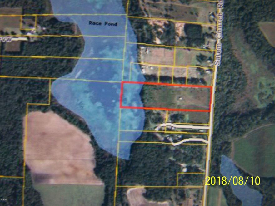 WATERFRONT 10 ACRE FARM/RANCH! Just west of Sneads, FL is this very nice 10 acre parcel of land, which fronts on and includes ownership of part of a large freshwater lake named Race Pond.  The property has been cleared and pastured, and includes a mobile home site on a small hill, complete with well and septic system (as is) and a nice utility room and carport, along with a sitting porch.  On the edge of the beautiful lake, sitting under some huge, heritage oak trees is even a rustic fishing cabin!  This parcel is accessed by a nice paved roadway from nearby Hwy 90.
