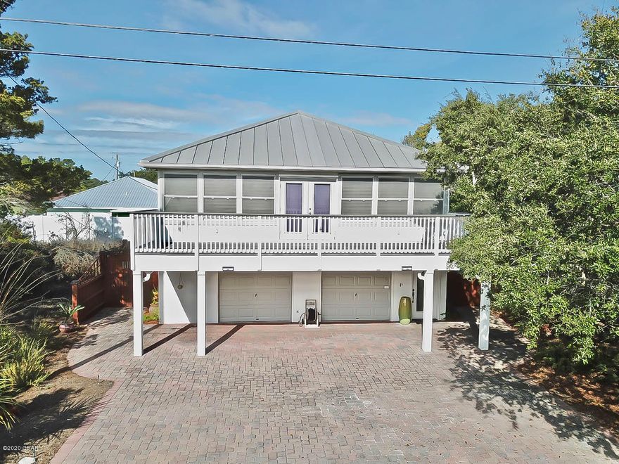 CURRENTLY UNDER CONTRACT, SELLER ACCEPTING BACKUP OFFERS'  No HOA! Walking distance to the beach!  Amazing vacation rental opportunity or make it you're primary or secondary home.  Open floor plan with living area and kitchen, Florida room and HUGE balcony on the second level.  This home provides two bedrooms and two bathrooms on second level and one bedroom with half bathroom on first level.  The oversized four car garage has so much potential to create more living space; such as a game area or bunk room.  In the backyard take time to relax with family and friends in the two screen patios or on the sun deck with tranquility garden. Hookup is already installed for a spa in one of the screen patios.  Whether you enter through the front or the back there is a shower at both places for you to rinse that sand off before heading into the house.  Don't miss out on your opportunity to own a slice of paradise!  This home isn't just about location it's about the living the beach life!!