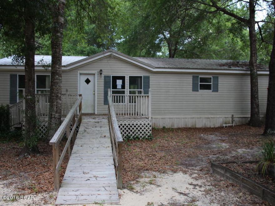 * PRICE REDUCED * 5 acres with chain link fencing and an interior fence around this lovely doublewide mobile home.Home has nice features that include a large living room with fireplace, split bedroom design and lots of room. The back yard features a large wood deck just right for entertaining and cookouts! There is a detached 2 car garage and a 2 car detached carport. If you like country living you will love this place! Conveniently located north of Panama City, home of some of the worlds most beautiful beaches!