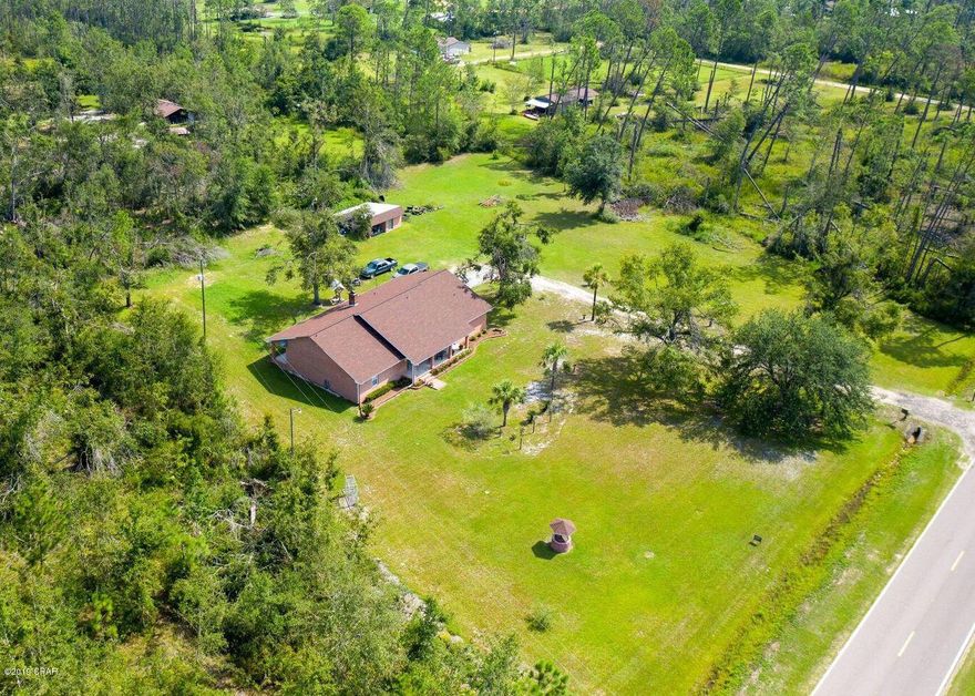 Beautiful Custom Built all brick home on 2 cleared acres. Just minutes from Bozeman School, and only a 15 minutes drive to Lynn Haven. Home boasts a split bedroom floor-plan. Buyers will love how private the master bedroom is, featuring a very large walk in closet, and a spacious master bath with tub and shower. The 2 additional bedrooms are very spacious, each with walk in closets, & separated by a jack and Jill bathroom. The kitchen does not lack storage space with lots of cabinets and a large walk in pantry, it also features a new stainless steel refrigerator and microwave, and an eat in nook directly off of the Kitchen. Additional space off of kitchen that could serve as dining room or office. Homeowner had structural support and energy efficiency in mind when building this home. The walls are reinforced with rebar every 8 ft with concrete inside the walls, as well as blown in insulation in attic.  May, 2016, AC Unit was replaced April 2015, New Septic July 2014, and deep well. Spend your days enjoying the beautiful nature around you on the 35 ft long front porch or the 46 foot long back porch. This home does not lack detail when it comes to the landscaping, as the homeowner has invested much time and detail into the beautiful flowers and plants along the home.