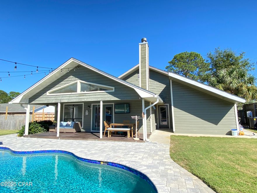 Welcome to the beautifully renovated home in the desirable Colony Club neighborhood! This spacious 4 bedroom, 3 bath home blends comfort, style, and functionality - just minutes from the beach, shopping, and entertainment. Step into the foyer and take in the unique solarium, a serene indoor- outdoor space perfect for morning coffee, reading, or creating your own garden retreat. The open floor plan connects the family, dining, and kitchen areas, creating the ideal layout for everyday living and entertaining. The tongue-and-groove vaulted ceilings, custom trim details, and a wood-burning fireplace give the living area a warm, inviting, and grand feel. The primary suite offers ample space for a seating area, has a large walk-in closet, and a newly renovated bathroom featuring a tiled shower, double vanities, and a private water closet. Two additional bedrooms each have their own bathrooms, plus a bonus room perfect for a bedroom, home office, gym, or hobby space. Step outside and discover your own backyard paradise- complete with a large covered porch, a heated pool with lounging area, and a Hot springs Aria salt water hot tub ($22,000 value) where you can unwind and enjoy breathtaking sunsets. *Also, this  home has solar panels that are paid for bringing the electricity bill down to a bare minimum. Recent updates include: New plumbing throughout the home and new sewer line to the street~ New zoysia sod, sprinkler system (front&back)~ New interior paint and skylights~ New appliances: refrigerator, microwave, double ovens~ UV filters added to both A/C units~ Updated lighting, new blinds, and fire alarms~ New pool heater and added hot tub~ With easy access to Highway 79, Panama City Beach Parkway, and the Gulf, plus nearby Holiday Golf Course, Gail's Trails, and Pier Park, this home offers both convenience and tranquility. Move-in ready, updated, and designed for relaxation- this one truly has it all!