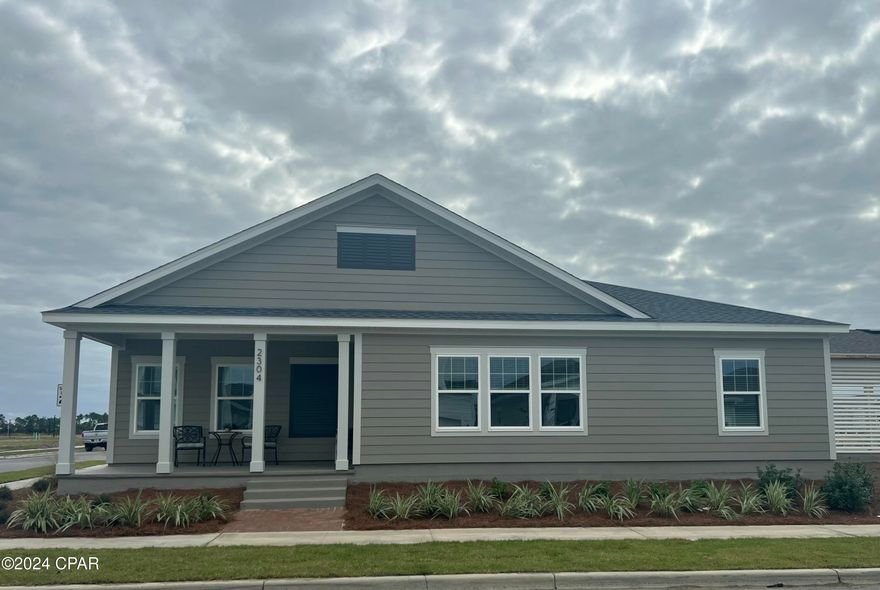 This low-maintenance lock-and-leave home is move-in ready in the popular waterfront community of SweetBay! This cottages are perfect if you're ready to stop doing yard work and enjoy the phenomenal lifestyle that SweetBay has to offer! The Magnolia III plan by Harris Doyle Homes is a thoughtfully designed open plan home with large covered front and rear porches and attached 2-car carport (optional garage) that could also be used for entertaining. This home includes granite countertops, stainless appliances and luxury vinyl plank flooring throughout the main living areas. The primary bedroom features a large walk-in closet and tile shower. SweetBay is a walkable and golf cart friendly community with unrivaled amenities: dock and boathouse with North Bay access for kayaking, paddle boarding, and fishing, parks, resort pool complexes, basketball and sports court, miles of trails, and planned future amenities including a town center and marina (groundbreaking this year)! New home buyers even get priority access to top-rated University Academy!