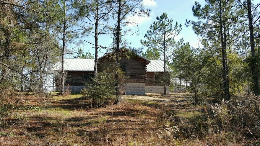 Use your imagination on this 5 bedroom, 3 bath log cabin built in 2007 and located on ten acres!  This is a shell and needs to be finished out. Two bedrooms and one bath on each side with master bedroom in back of home. Property appraiser has it valued at $204,000 so this is priced to sell!