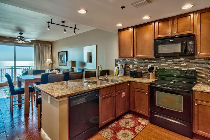 This Fully Furnished End Unit. Features Include 3 Bedrooms, 3 Full Baths, 9ft Ceilings, Upgraded Wood Tile Floors Through Out, Granite Countertops, Fully Applianced Kitchen with Upgraded Tile Backsplash, Breakfast Bar and Tiled Backsplash, Dining Room, Living Room, Large Terrace with Your Own Private Grill & Magnificent Views is Accessible off the Living Room and the Owner Suite, Complete Electronics Package Including Flat Screen Televisions. Can Easily Sleep Up To 10 People. World- Class Amenities Include: State-of-the-Art Fitness Center, Wine Bar, 2,000sq. ft. Heated Tropical Pool and Whirlpool Spa, Poolside Umbrella and Beach Chair Service, Community Activity Room, Secure Parking, and So Much More! All This Located Only Steps Away from Pier Park Mall... As Always, Buyer to Verify Square Footage, Dimensions, HOA Fees & Dues