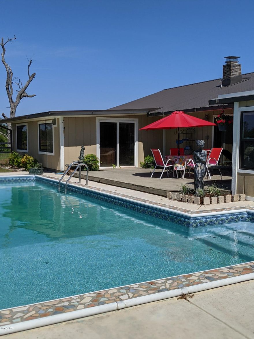 CURRENTLY UNDER CONTRACT, SELLER ACCEPTING BACKUP OFFERS'

Country living at it's finest, 20 acres on a paved road, with a home, barn and fenced pasture only 30 minutes from center of Panama City  and  Tyndall AFB,. Escape the crowded neighborhoods on this beautiful 20 acre parcel of property that is ready for you and your horse! You'll love the large 2000 sq ft plus home that has a new pool and new roof!  The open floor plan gives you space to enjoy the living area, the dining room, to the kitchen and the enclosed patio and still be able to hang out together. The bedrooms are spacious with ample closet space! The master is spacious with an additional area that can be made into an office or private den area. The two story barn has 12x12 stalls with fans and is equipped with a custom tack room, sink area and wash area for the animals.
You'll also find a brand new metal building close to the house that has plenty of storage and covered spaces to store equipment or have additional parking. The beautiful homestead has pecan trees lining the drive to the house from the paved road. It is a must see to truly appreciate all it has to offer!