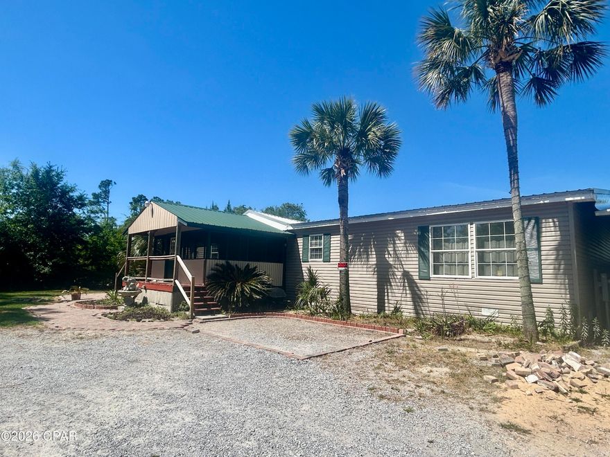 Spacious 3BR/2BA manufactured home offering 2,432 sq ft of comfortable living in a peaceful country setting--just 4 miles from Lynn Haven. This home features oversized bedrooms, each with large walk-in closets, and a relaxing primary suite complete with a soaking tub.

The open-concept layout includes a generously sized kitchen with a large island--perfect for entertaining--along with all new appliances installed in October 2025. Cozy up by the wood-burning fireplace or enjoy quiet mornings on the screened front porch.

Additional upgrades include a newer water heater (2024) and underground electric for added safety during storms. Outside, you'll find an oversized 3-car garage, two storage sheds, and a huge backyard with plenty of space for chickens or other animals.

Located just 0.4 miles from a convenient boat ramp on Fanning Bayou. This property offers the perfect blend of country living with easy access to the water and nearby amenities. The home needs new floor covering in all rooms except the primary bathroom, which is tiled. All measurements are approximate.