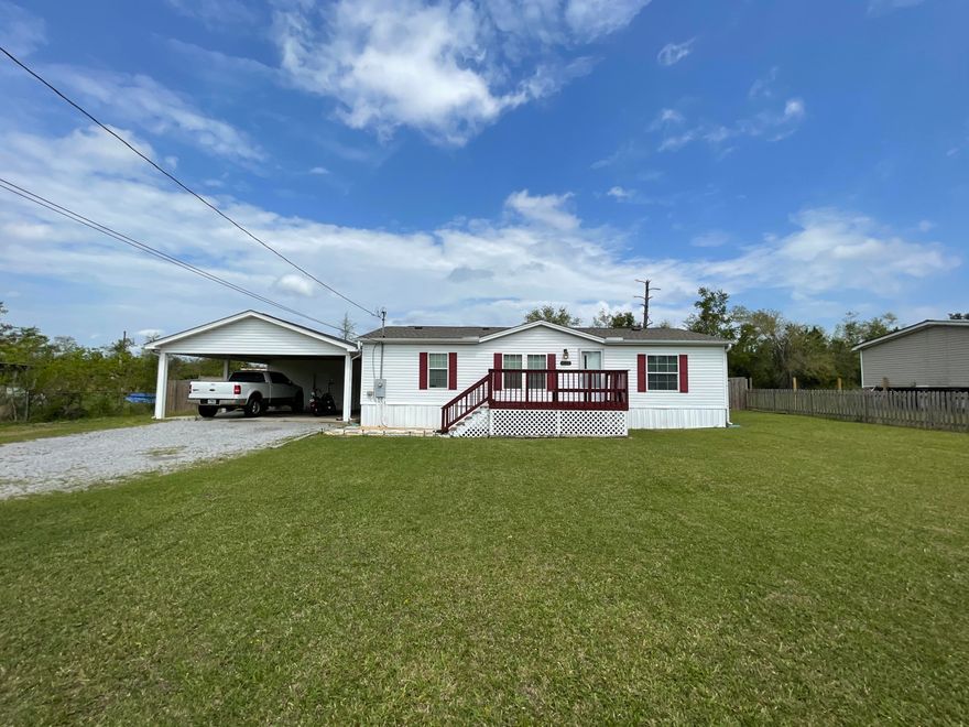 Very nice double wide mobile home in Northern Panama City. Great home on one-half acre. Interior includes 3 spacious bedrooms & 2 baths with a split floor plan. All 3 bedrooms have walk-in closets. The master bathroom has a double vanity, shower, linen closet, & access to the laundry area. The kitchen includes a new dishwasher, newer electric range, plenty of cabinets, & a breakfast bar that overlooks the living room. French doors in the dining area lead to a large back deck that opens to the fully fenced back yard. Exterior of home includes a large double carport with attached storage room. Storage room is insulated to assist with climate control & also includes an attic for extra storage. New roof was installed on home & carport in 2019.