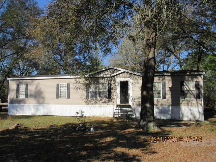 This home is ready for you to view. Kitchen is designed for function and entertaining. Appliances are included. Lots of room to spread out in this 1,560 square foot home on 1.38 acre parcel. Beautiful shade trees and quiet living. Sit on the deck and make your own atmosphere area. Large bedrooms, good size laundry room, Garden tub in master bathroom. Wood burning fireplace, walk in closet, double vanity. Home is on private well and septic. This home is ''Must See''. Only minutes from The Worlds Most Beautiful Beaches, Famous Pier Park Shopping, Tyndall Air Force Base,  Call today for your private showing.