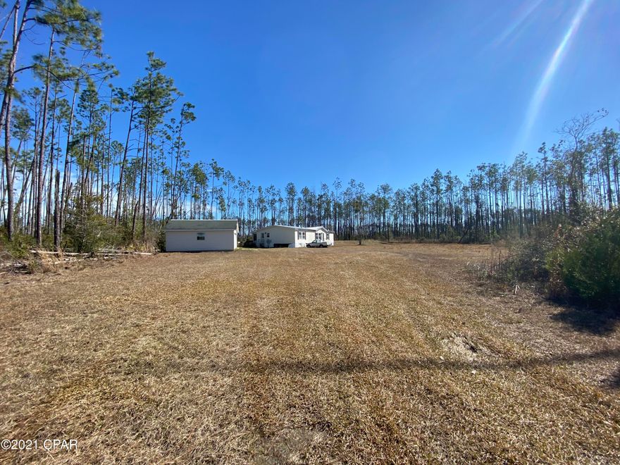 10 acres of land with large mobile home in the northern part of Panama City.  This 3 bedroom 2 bath home sits on 10 acres that is partially cleared and has a detached double car garage.  The home offers 3 large bedrooms each with walk in closets and a split bedroom floor plan.  The extra large living room has  wood burning fireplace.  There is a large Florida room off the kitchen and dining area.  There is a new roof and new carpet.  Call to see today!