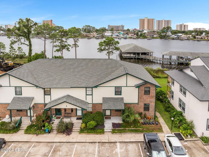 Panama City Beach waterfront townhome with boat slip and 6,000 lb lift! Don't miss this tranquil property that is away from the hustle and bustle of Front Beach, but close to the best restaurants, beach accesses and attractions.  This 2 bedroom, 2.5 bath townhome is located in Greenwood Estates community.  The home features a kitchen, breakfast bar, dining area, living room and half bathroom on the first floor.  Highlights include kitchen pantry, tile floors, storage, fireplace, and Florida room to enjoy the beautiful view of the lagoon.  Upstairs is a guest bedroom with attached guest bath and a master bedroom with updated attached bathroom featuring a walk in shower.  Outside is a back open patio perfect for grilling.  HOA fees are $176/month and include a community pool and lawn maintenance.  The unit comes with one reserved parking space in front of the unit, but there is guest parking nearby.  The covered boat slip fee is $380/year and includes a new dock with power and water.  The sellers pontoon boat is available to purchase separately if interested.  Owners pets are allowed.  Short term rentals are not allowed.  Roof was replaced in 2019, Water Heater in 2024 and AC in 2012.  Make plans to see this beautiful property today!