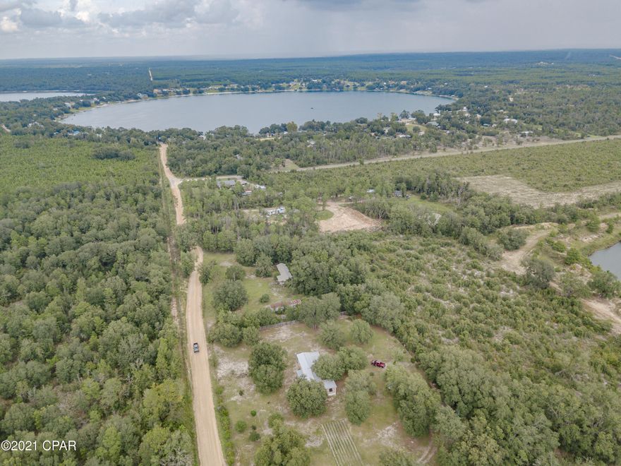 CURRENTLY UNDER CONTRACT, SELLER ACCEPTING BACKUP OFFERS. Immaculate singlewide with add on bedroom and multiple porches on two acres less than a mile from Crystal Lake! Beautifully maintained two acres completely fenced in with majestic shade trees and garden space! Pomegranate, Avocado, and citrus trees! Two outbuildings, deep well, and plenty of room for a garden! There is a second septic tank on the property for the possibility of an additional home. New roof in 2019! New windows, and siding in 2010! Less than a mile from Crystal Lake boat ramp, only 20 minutes to the airport, and 30 minutes to the beautiful white sands of PCB! Please verify all measurements and information.