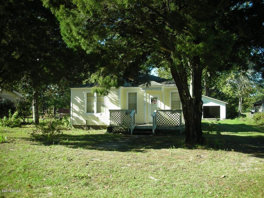 REDUCED!! Florida Cottage style home located in a great neighborhood in the heart of Port St Joe. This 2BR/1B home has a bit of character and charm with gas fireplace and wood arched design dividing living from dining. Built in 1968 this home has some of the original features of doors and hard wood floors under carpet. The kitchen has some newer cabinets but needs some remodeling. Bonus room off Master Bedroom could become a 2nd Bath or closet. Large Deck on back of home. The AC is about 5 years old. Vinyl siding 8 years old. Roof 10 years old. Rewired 7 years ago. Out back is a 30' x 40' concrete block two car garage plus laundry room and storage room. Big yard with plenty of room for your boat, RV, etc. Bike/Jogging path, parks, and small lake nearby. Being Sold ''AS IS''.