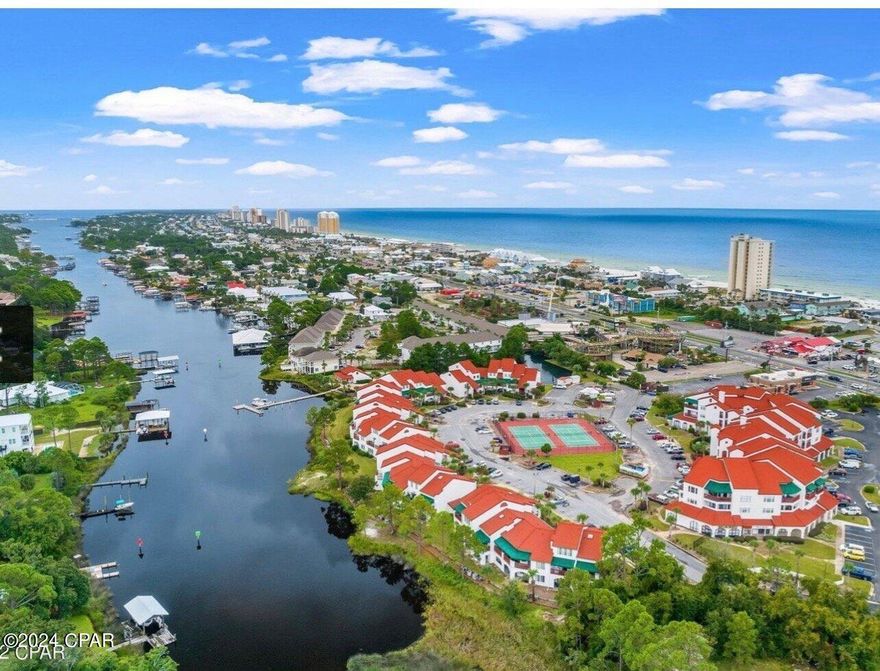 Rental Ready condo in PCB with Lagoon View and 5 min walk to the beach. Well maintained 1 bedroom, 1 1/2 bath condo in the quaint and gated community of St. Thomas Square. This condo has been well cared for by long term tenants for the past 4 years.  This condo comes FULLY FURNISHED and ready to move in or use as 2nd home/ rental property. Vacation Rentals ARE ALLOWED. Wood look plank tile floors throughout helps for easy cleaning. The AC unit inside and out were replaced in 2022 and the Hot Water Heater in 2021. The master bedroom has a queen bed, and the sofa is a sleeper. Relax out on the covered porch and enjoy the view out to the lagoon.  This complex is unique as the lagoon that surrounds it will take you out to Shell Island and the Gulf. The community offers a dock for residents to use to come and go and there is even boat parking available on site. Large Lagoon front pool and community center with plenty of areas to sit and relax.  The community is gated for privacy. Attached to this complex is a commercial building that offers a yummy Mexican restaurant, wine shop, boba tea & smoothie shop and more. Make sure you make plans to see this beauty!