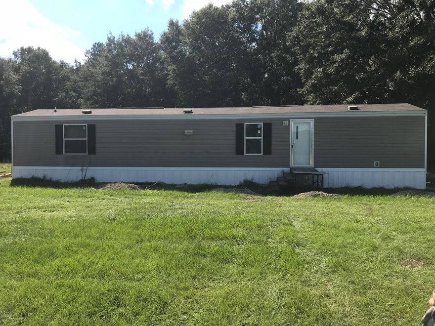 Great property just waiting for your dream home!  This property has a brand new 2017 2 Bedroom 2 Bath mobile home with a brand new septic system large enough for a 5 bedroom house.   This 9 acres lot features a large enclosed pole barn and plenty of room for a few horses.  The barn includes 5 Steel Roll Doors, Steel Rafters, 30 X 50 enclosed and insulated bay to accommodate an RV. Reinforced concrete slab with Indoor and Outdoor Septic and Indoor and Outdoor Electric 30 and 50 amp RV hookups. This large area is also plumbed for a full bathroom and includes an attached Utility room that houses the well pump and a washer and dryer area. Opposite this area is a 12 X 24 Bunk House with storage on top.  There is an open bay on the outside that would make great stalls for your horses. Make an appointment today to come and relax under the breezeway and see all this property has to offer!!!