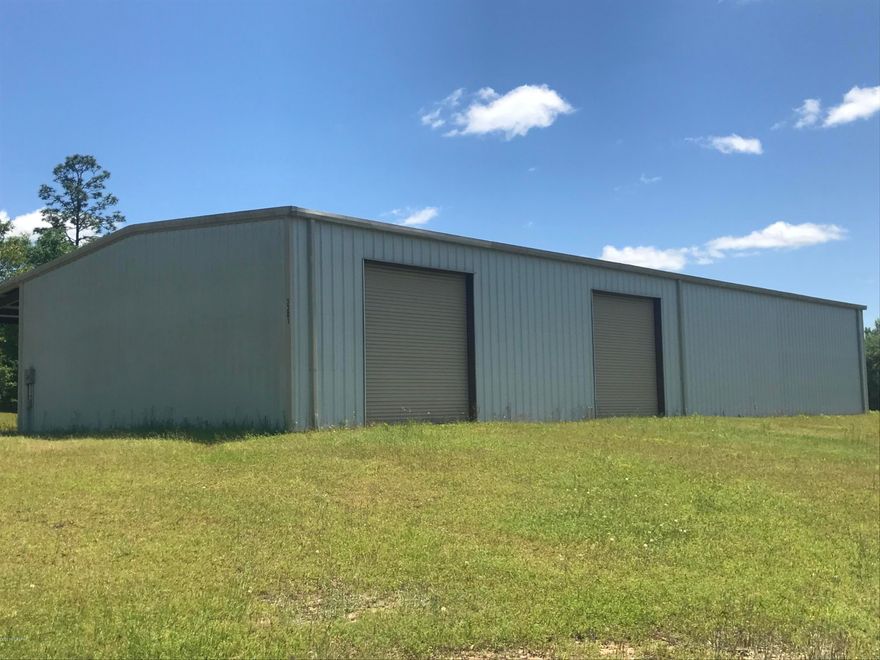 Commercial Bldg on 20 beautiful acres.  Rolling acreage with big oak trees. 1/3 of bldg is insulated and could be used as a residence. 4-12 ft roll up doors.  6'' commercial concrete floor. The 60x100 roof is insulated.  4'' deep well with air compressor inside pump house for quiet operation. A well thought out landscape.  9 min to I-10 for easy access .  Just across from McCormick Lake.  Make an appt. today.