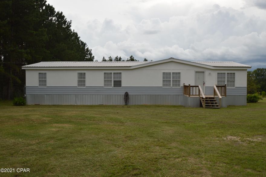 Nice looking doublewide mobile home on 2 acres just outside of town. All new paint ,new flooring ,blinds, fixtures , 3 bedroom 2 baths with walk in closest in all bedrooms. Open kitchen living area, great back deck. Country living but yet close to everything.Two acres being cut out of 22 acres  so tax information isn't correct.