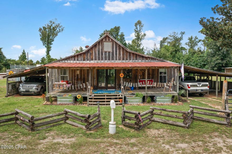 Escape to the tranquility of country living with this charming and rustic farmhouse retreat, nestled amidst lush greenery. This unique property offers a serene escape back to the days of sipping fresh sweet tea on the wrap-around porch watching the kids play in the yard and no worries. This classic 2 Bedroom 1 Bath farmhouse features so much you may never want to leave the comfort of your new home. The home features a weathered metal roof and inviting wrap-around porch, new above ground pool and a new 12x24 deck to soak up the Florida sun. The inside of the home was completely remodeled in 2019 including a gas stove, dishwasher, cast-iron farmhouse sink (1959-refurbished), water heater, blown in insulation, new front and back French doors, full bathroom, central HVAC system, well pump (2023), aqua pure home filtration system and so much more!!! There is another room that is currently used as a 3rd Bedroom but can be a playroom or an office! There is a separate 12x24 quaint outbuilding that provides additional versatile space in the Bunk house that has electric and plumbing and includes a full bathroom! Perfect for the grandkids, or a separate place for your guest to have their own privacy. There is a 3 bay Pole Barn, a playhouse for the kids and chicken Coop. All of this may look ''old'' but all the outbuildings were built to match the rustic farmhouse look within the past 7 years! Fish or relax in the swing overlooking the fully stocked pond with Bream, worm mouth, catfish and bass.  Experience the allure of rural life with ample open land, a sturdy split-rail fence, and a brand new welcoming entrance gate, all contributing to the quintessential ''Farmhouse Lifestyle.'' Less than 5 minutes away from Shopping and I-10. Call us today for your personal showing!!