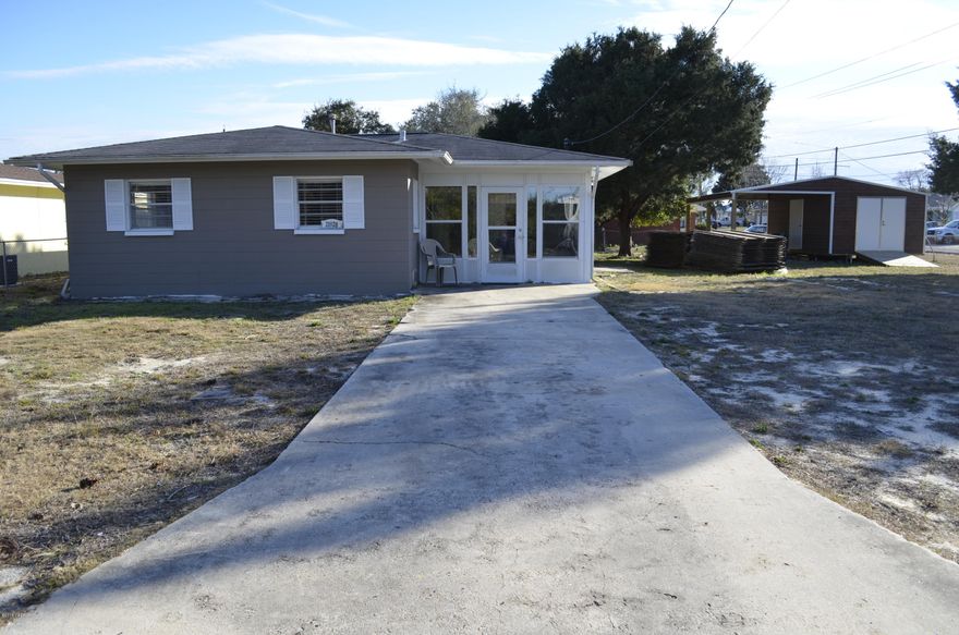 This is your opportunity to own a charming updated  Floridian block home on a DOUBLE LOT (95x107). You have room to add onto this existing home or possibly build another home right next door, endless possibilities! This is a Golf Cart Friendly Community and a short walk to the beach. Being sold furnished minus a few personal items that will be removed. Notice the crown molding, bamboo laminate flooring, ceiling fans in all rooms, quality furniture and  the recessed lighting in living room. New A/C was installed in 2016. Large 12x18 sun room (not included in square footage) that is a great space for entertaining. New(2017) 12x20 golf cart shed/workshop with an additional roofed area perfect for storing a boat or car. A NEW METAL ROOF is being installed in a few weeks.
