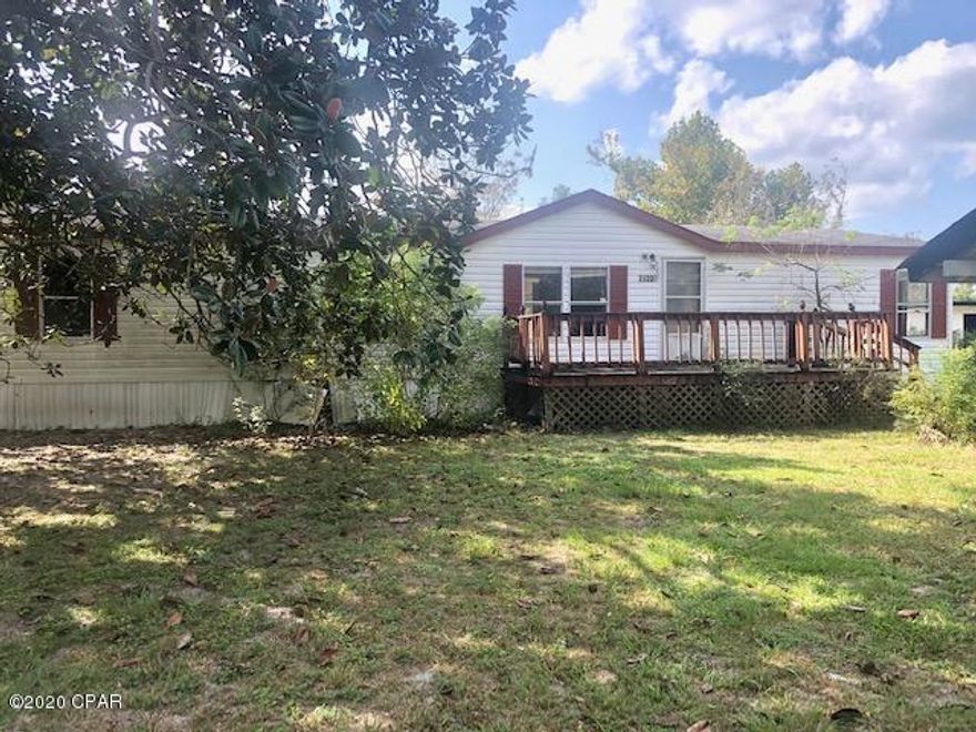Double wide mobile home in the country on almost an acre of land.   The home has suffered damages from the hurricane but it is a good investment property that you could fix it up or remove from the lot and replace it.  It has a large living room, large kitchen and a den with fireplace.  It also has an outside storage building with a carport on the side.  One of the lots goes all the way through to the street behind.    It is very close to Lake McKenzie.